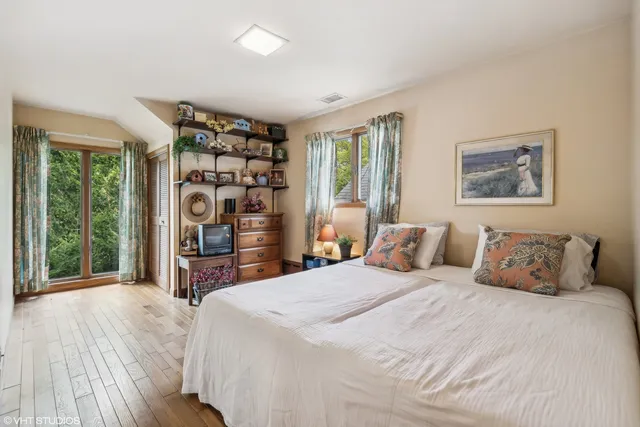 a bedroom with a bed chair and a large window