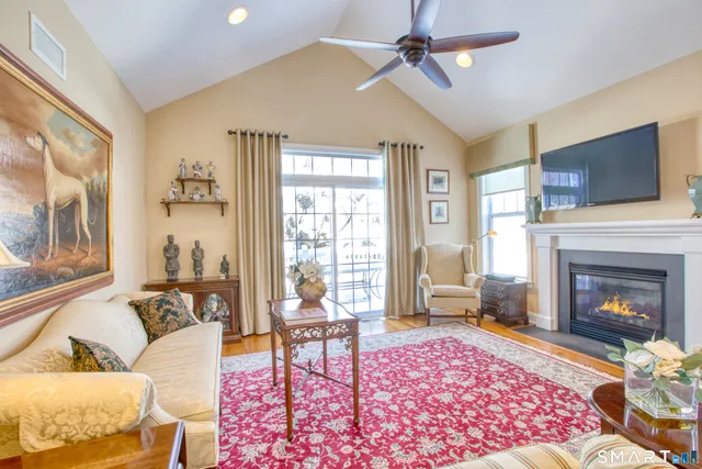 a living room with furniture a flat screen tv and a fireplace
