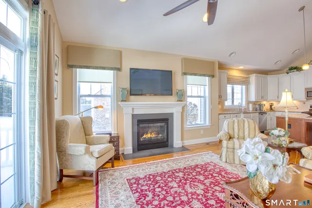a living room with furniture a flat screen tv and a fireplace