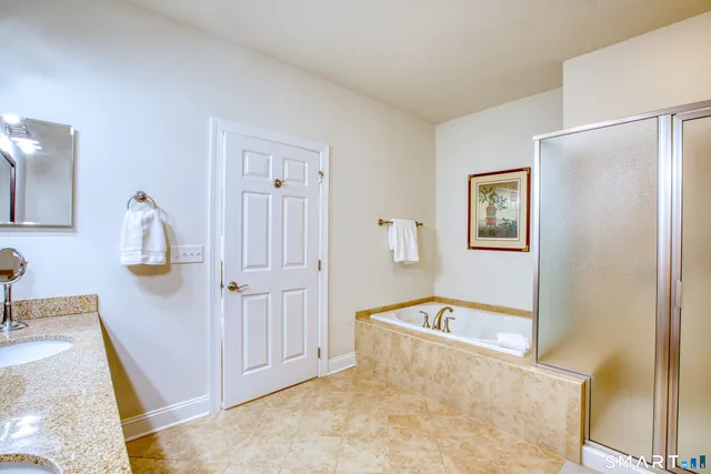 a view of a livingroom with wooden floor and a bathroom