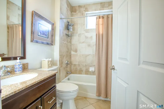 a bathroom with a granite countertop sink toilet and shower