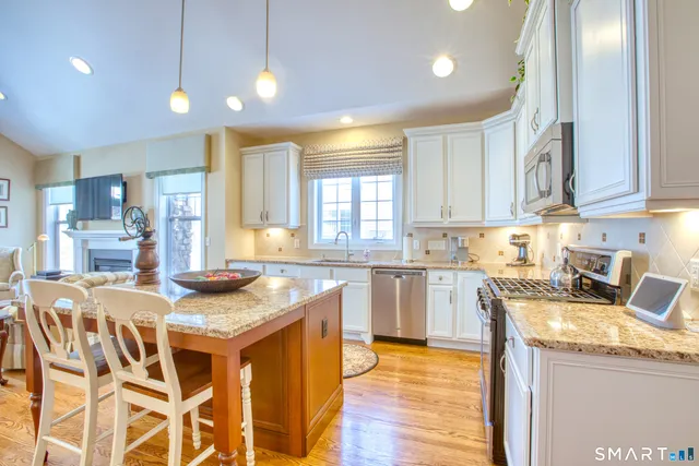 a kitchen with granite countertop kitchen island wooden cabinets and refrigerator