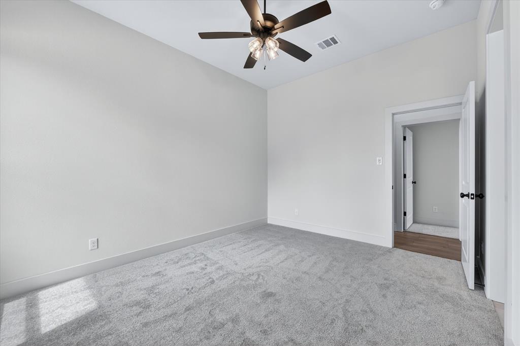517 Longhorn Lane Springtown, TX 76082 - Photo 28 of 39 Empty room with light colored carpet and ceiling fan