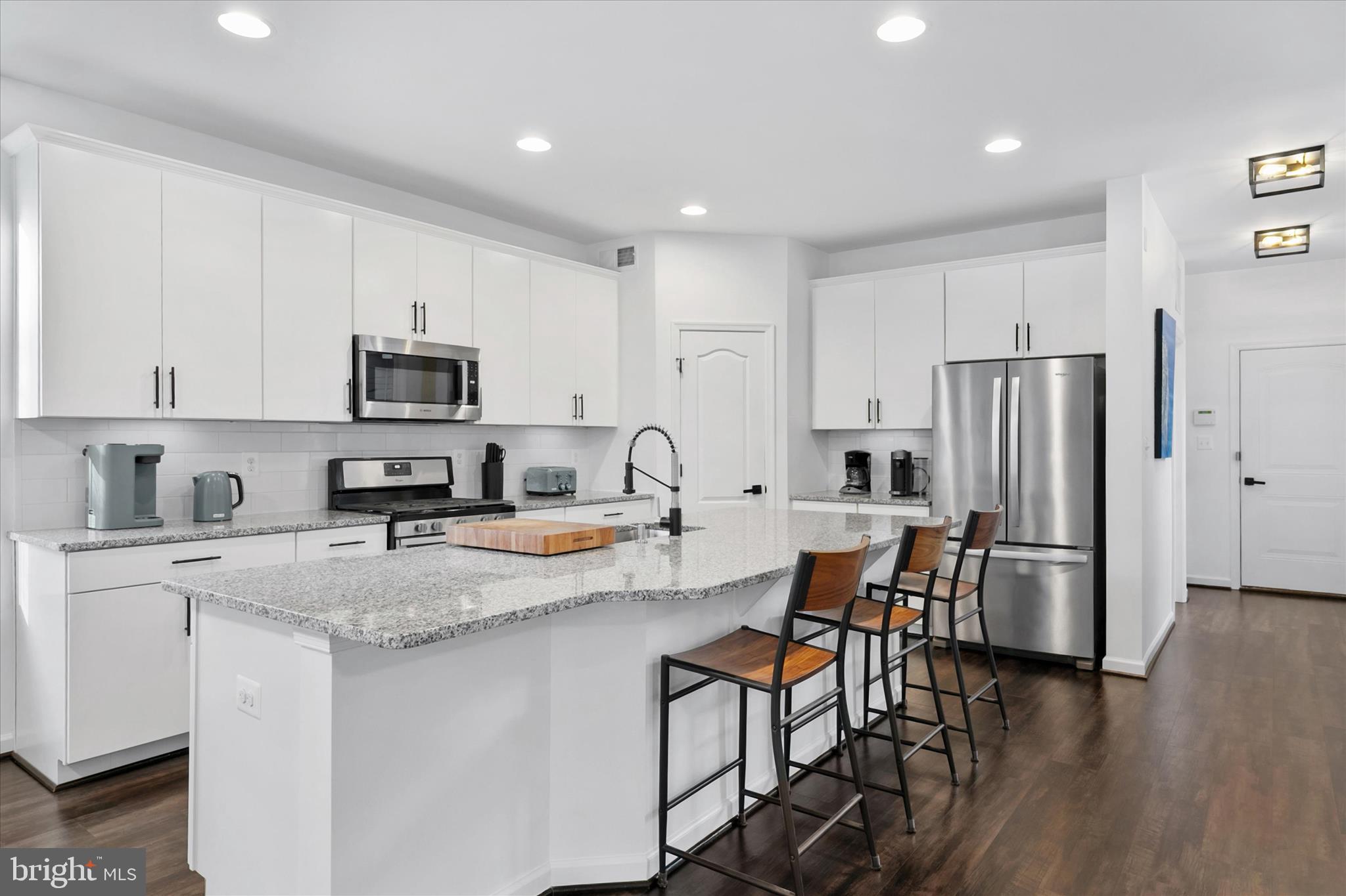 36114 Watch Hill Road Frankford, DE 19945 - Photo 15 of 80 a kitchen with stainless steel appliances granite countertop a refrigerator a stove top oven a sink dishwasher a dining table and chairs with wooden floor