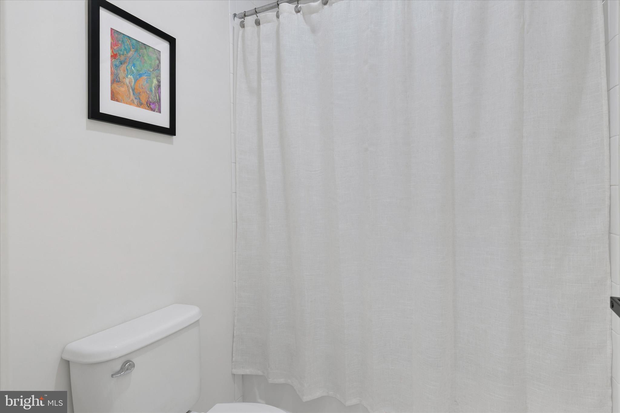 36114 Watch Hill Road Frankford, DE 19945 - Photo 27 of 80 a white toilet sitting next to a shower curtain