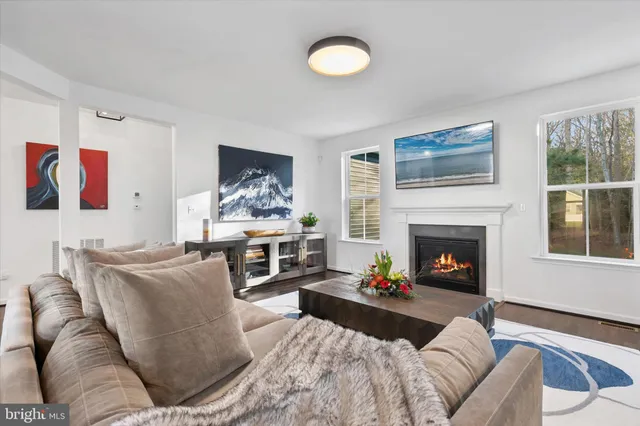 a living room with stainless steel appliances kitchen island granite countertop furniture wooden floor and a kitchen view