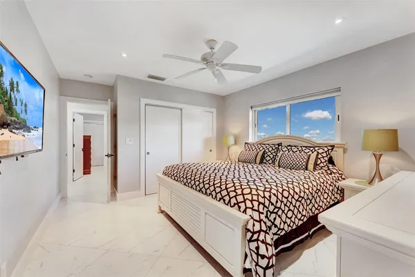 a bedroom with a large bed and ceiling fan