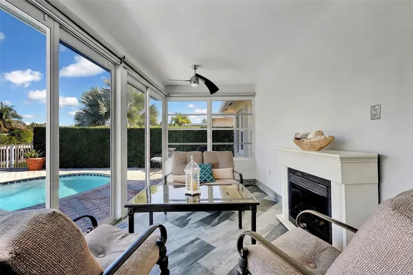 a view of a patio with table and chairs potted plants with floor to ceiling window