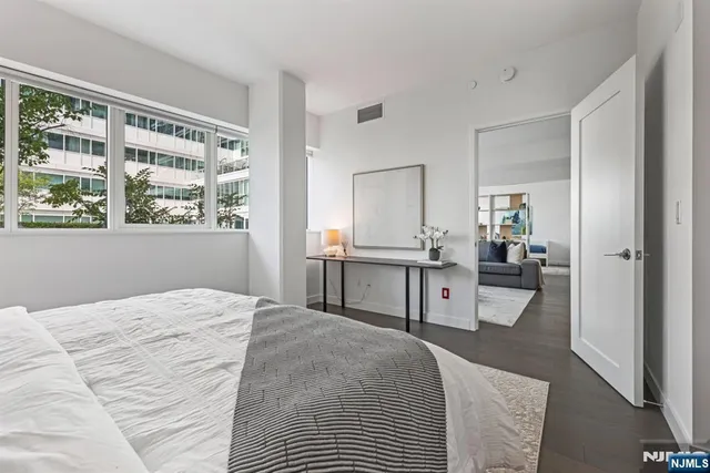 a bedroom with a bed and a large window