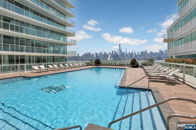 a view of a swimming pool with seating space and deck