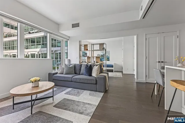 a living room with furniture a rug and kitchen view