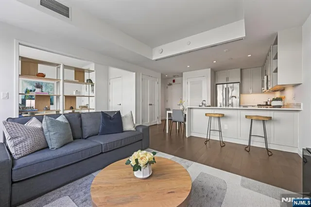 a living room with furniture and kitchen area