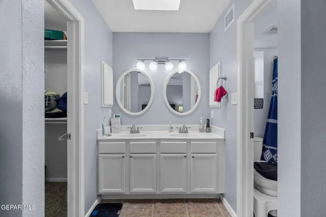 an empty room with a chandelier fan and a window