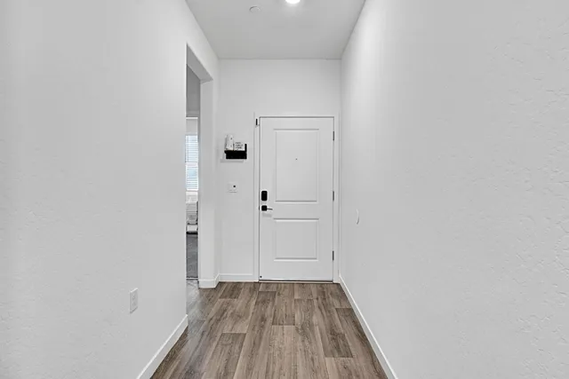 a view of a hallway with wooden floor