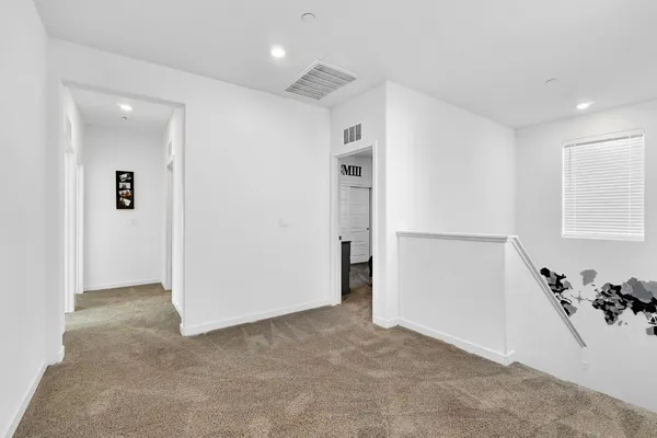a bedroom with a bed a dresser and a chandelier