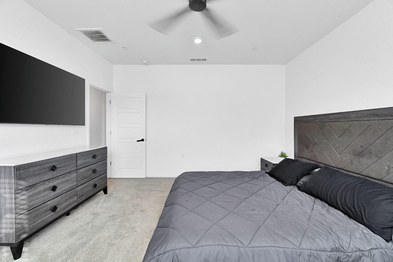 2831 North Redda Road Fresno, CA 93737 - Photo 35 of 41 a bedroom with a bed and a flat screen tv