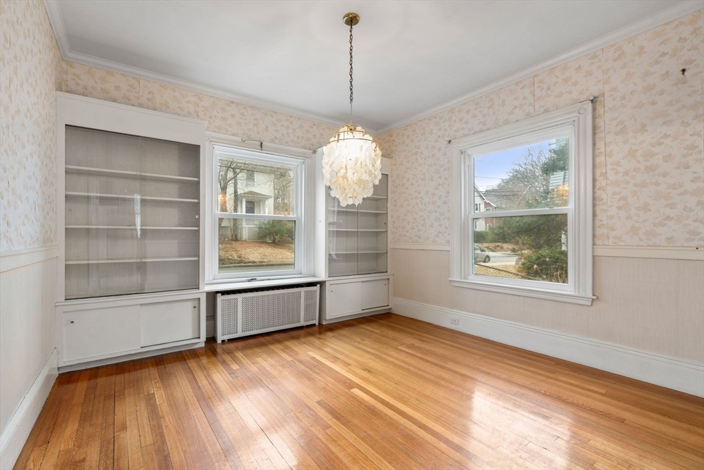 187 Clark Road Brookline, MA 02445 - Photo 12 of 40 a view of an empty room with a window and wooden floor