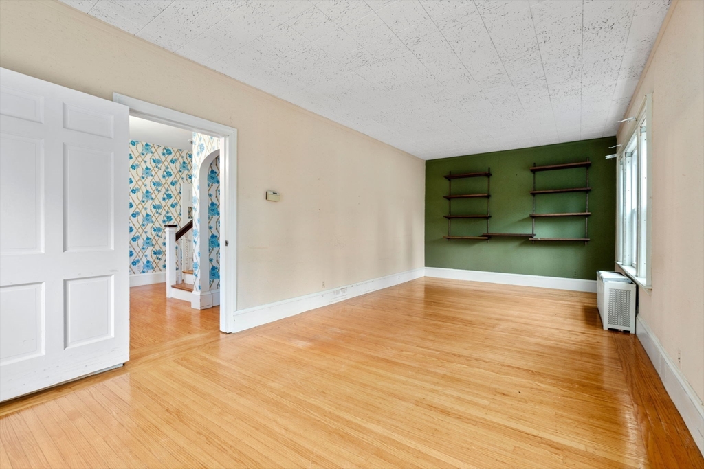 187 Clark Road Brookline, MA 02445 - Photo 13 of 40 a view of an empty room with wooden floor and a window