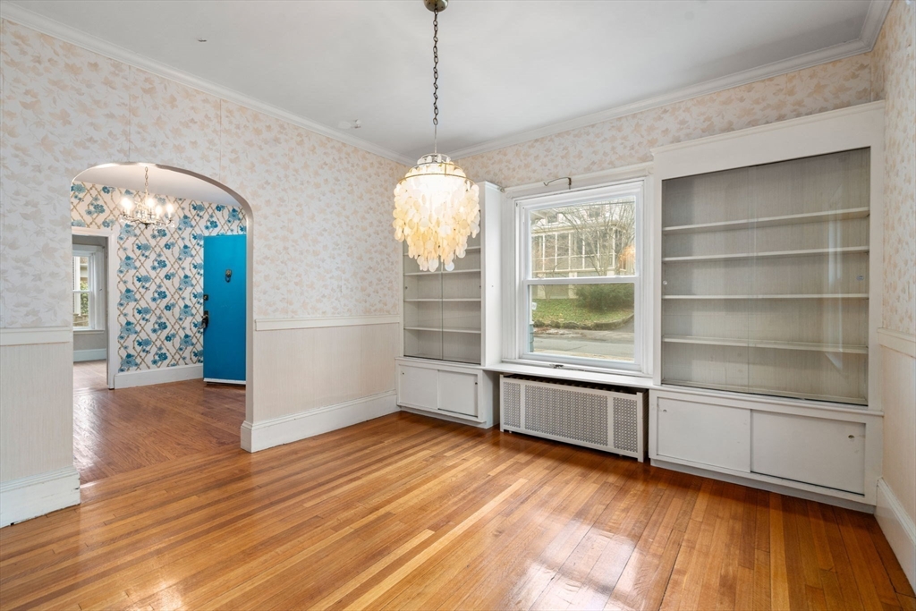 187 Clark Road Brookline, MA 02445 - Photo 2 of 40 a view of an empty room with a window and wooden floor