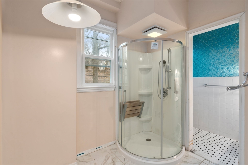 187 Clark Road Brookline, MA 02445 - Photo 28 of 40 a bathroom with a glass shower door and a sink
