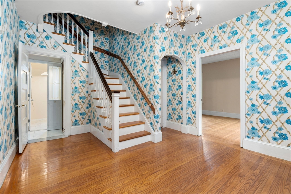 187 Clark Road Brookline, MA 02445 - Photo 4 of 40 a view of a hallway with wooden floor and staircase