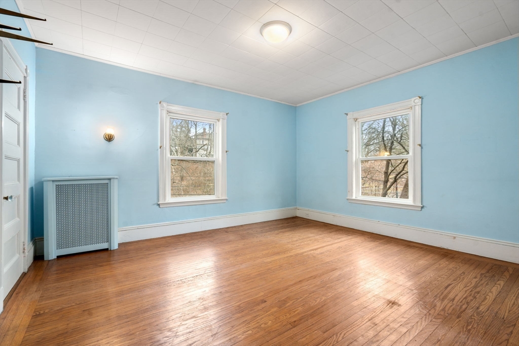 187 Clark Road Brookline, MA 02445 - Photo 8 of 40 an empty room with wooden floor and windows