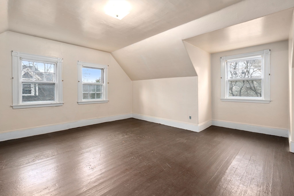 187 Clark Road Brookline, MA 02445 - Photo 9 of 40 a view of an empty room with wooden floor and a window