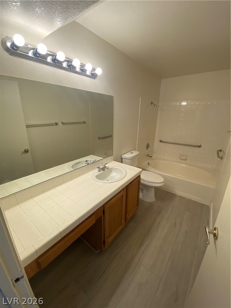 7570 West Flamingo Road, Unit 125 Las Vegas, NV 89147 - Photo 6 of 29 Full bathroom featuring dark wood-type flooring, vanity, and washtub / shower combination