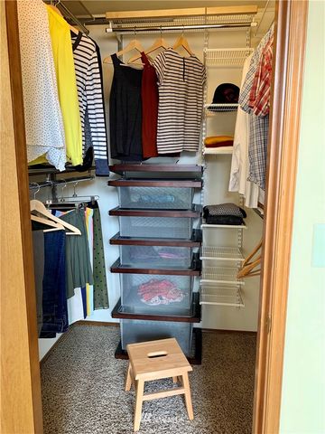 a view of walk in closet with clothes and shoes