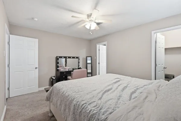a bedroom with a large bed and a ceiling fan