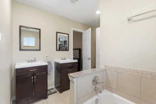 a en suite bathroom with a granite countertop sink and a mirror