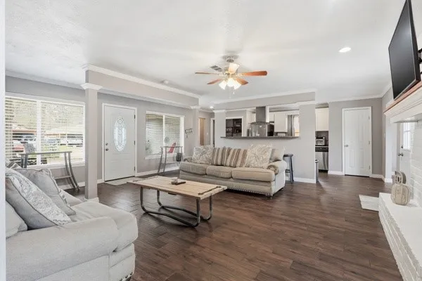 a living room with furniture ceiling fan and a wooden floor