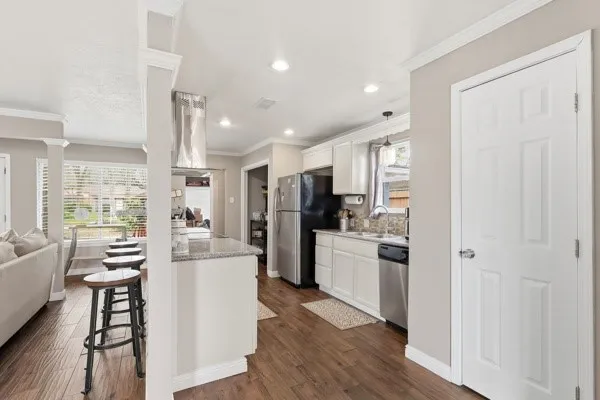 a kitchen with refrigerator a stove and wooden floor