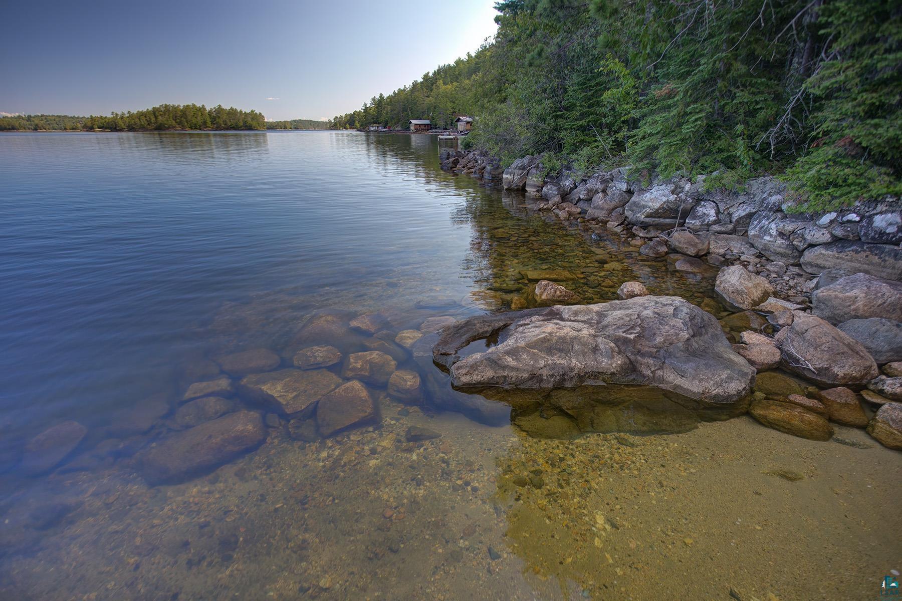 2815 Schaeffer Road Ely, MN 55731 - Photo 24 of 37 Waterfront property featuring a natural rocky shoreline, clear water, and mature trees along the bank