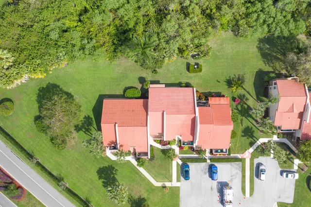 an aerial view of residential houses with outdoor space and trees