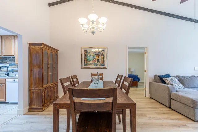 a view of a dining room with furniture a chandelier and wooden floor