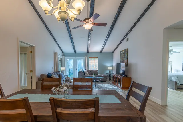 a living room with furniture a chandelier and a piano