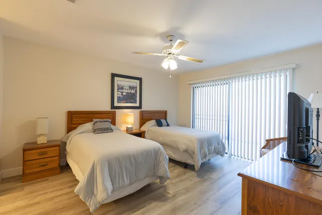 a bedroom with two beds and a flat screen tv