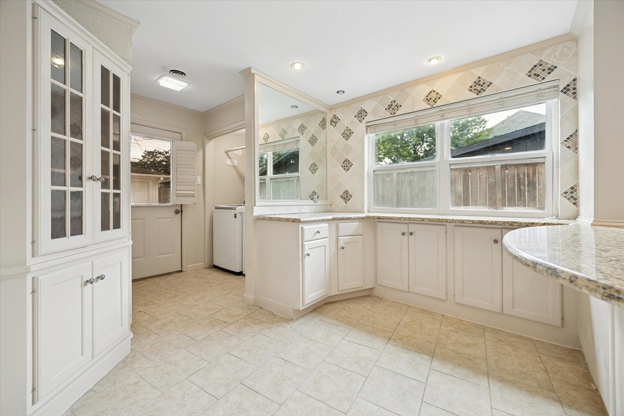 4919 Valkeith Drive Houston, TX 77096 - Photo 12 of 29 a large white kitchen with cabinets and outdoor space