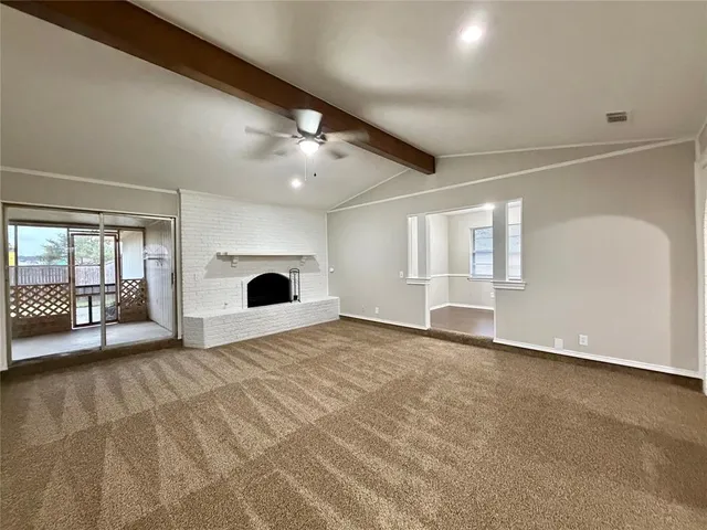 a view of an empty room with a fireplace and a large window