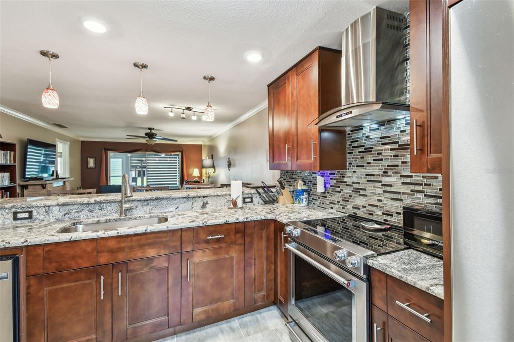 7200 Ulmerton Road, Unit E3 Largo, FL 33771 - Photo 7 of 26 a kitchen with stainless steel appliances granite countertop a sink stove and cabinets
