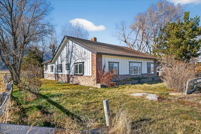 a view of a house with wooden deck and furniture