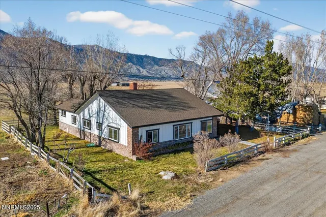 a view of a house with a large tree and a yard