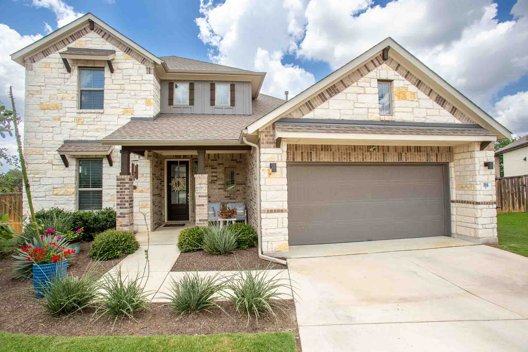 Elegant brick and stone facade welcomes with charming curb appeal and a convenient attached garage.