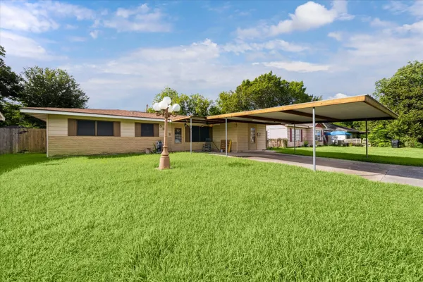 a view of house with a backyard