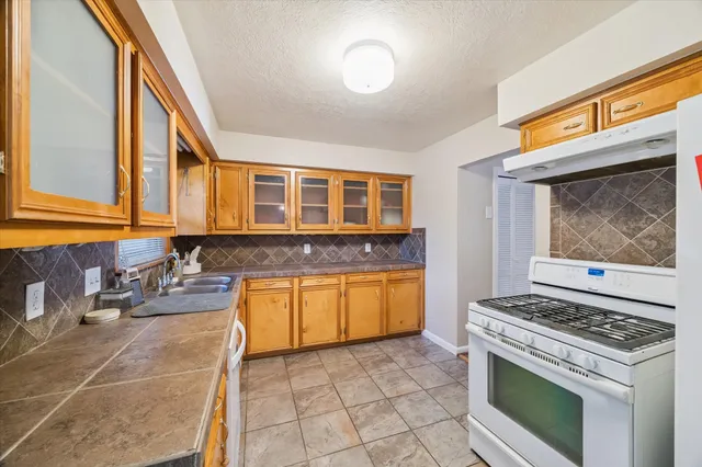 a kitchen with stainless steel appliances granite countertop a stove a sink and a microwave