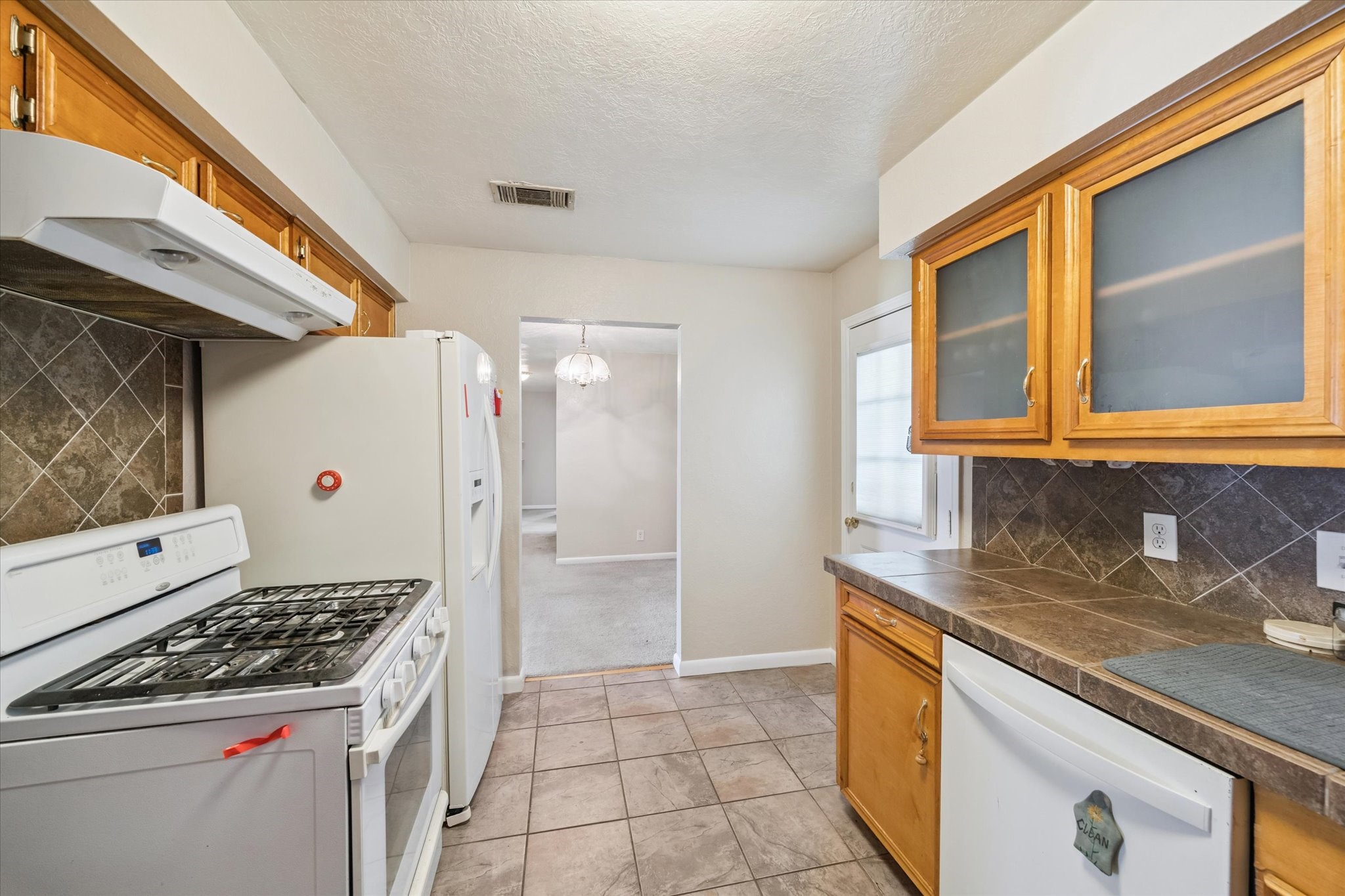 5618 Sweetbriar Street Houston, TX 77017 - Photo 8 of 15 a kitchen with a stove a sink and a refrigerator