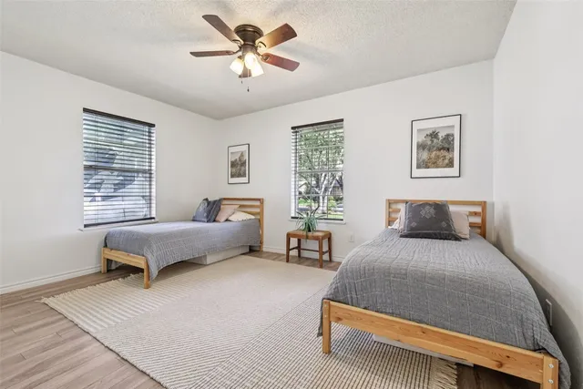 a bedroom with a bed and a potted plant on the dresser