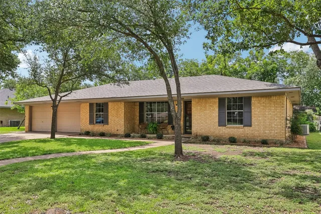 a front view of a house with a yard and trees