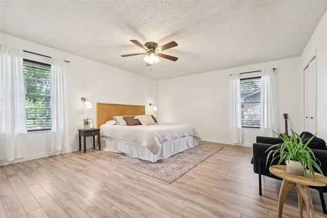 a spacious bedroom with a bed and a chandelier
